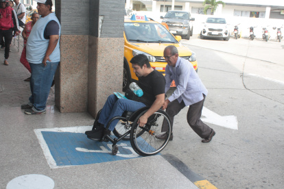 Discapacidad. Luis Morán necesita apoyo a diario para subir la rampa que está ubicada en el ingreso a la Unidad Judicial Albán Borja, en el norte de Guayaquil, donde labora.