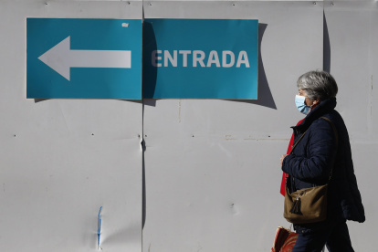Una mujer con mascarilla camina en el entorno de un centro de salud en Madrid este 8 de enero de 2024, día en el que el Ministerio de Sanidad ha pedido a las comunidades que implanten el uso obligatorio de la mascarilla en centros sanitarios y sociosanitarios.