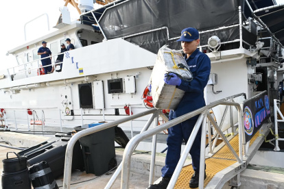 Un miembro de la tripulación del buque guardacostas Margaret Norvell mientras descarga paquetes decomisados con más de una tonelada de cocaína, valorada en más de 32 millones de dólares hoy, a Miami, Florida (EE.UU.).