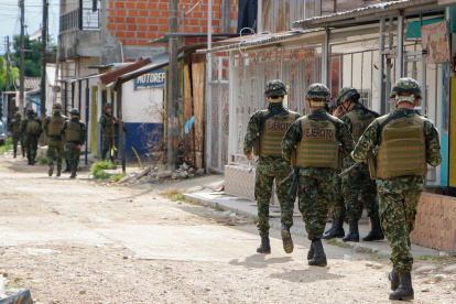 Soldados del Ejercito colombiano recorren una calle de una población rural.