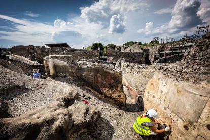 Un arqueólogo trabaja en un mural descubierto durante los trabajos de excavación en el sitio arqueológico de Pompeya, en Pompeya, cerca de Nápoles, Italia.