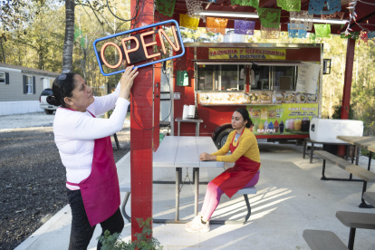 Yelva Cortés (i) y Yolanda Romero (d), ambas naturales de Michoacán (México), esperan clientes en el restaurante móvil donde trabajan en el condado Liberty.