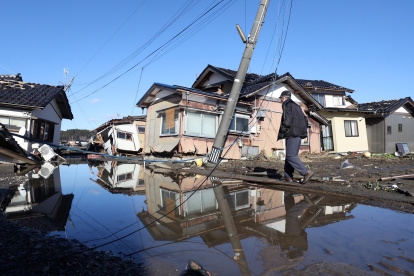 Una persona transita por una zona inundada, escenario del fuerte terremoto que afectó a Japón el 1 de enero de 2024, en la prefectura de Ishikawa.
