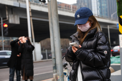 Una calle de Pekín, donde varias personas aparecen en diferentes ocupaciones.