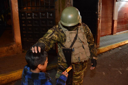 Quito de noche - un niño se acercó a un militar a regalarles chocolates