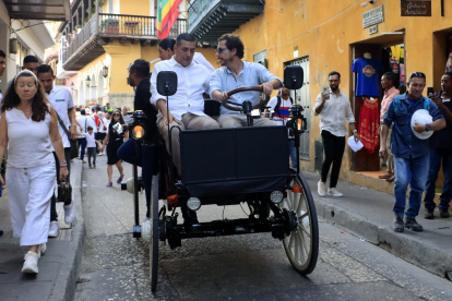 El comediante Alejandro Riaño (d) y el alcalde de Cartagena, Dumek Turbay (i), prueban el prototipo de coche eléctrico
