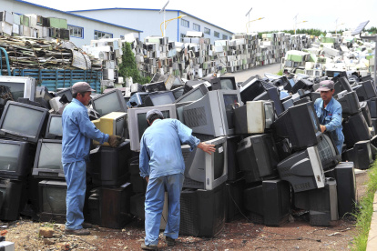 Trabajadores desarman electrodomésticos y artículos electrónicos en un centro de reciclaje en Tieling City, al noreste de China, en una imagen de archivo.