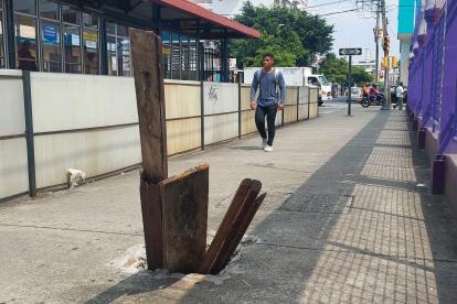Con tablas de madera cubren una alcantarilla sin tapa en las calles Primero de Mayo, entre Carchi y Tulcán.