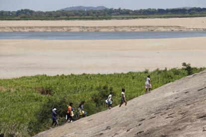 Varios desplazados caminan cerca de un río de Colombia.