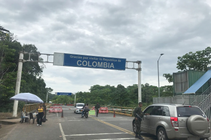 Algunos vehículos pasan por el puente fronterizo sobre el río Mataje, pese a la prohibición de circulación.