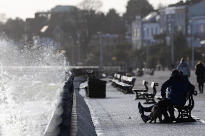 Un grupo de personas observa cómo las olas rompen sobre el malecón en New Brighton, Gran Bretaña, este 22 de enero de 2024.