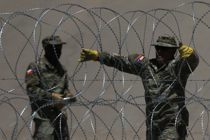 Miembros de la Guardia Nacional de Texas al reforzar la frontera con alambre de púas aceradas, debajo del Puente Internacional Reforma, frente a Ciudad Juárez (Chihuahua, México).