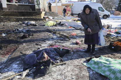 Una mujer camina entre los cuerpos de las víctimas del bombardeo del mercado de alimentos de Donetsk, Ucrania, este 21 de Enero.