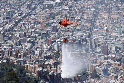 Un helicóptero participa en labores de extinción de los incendios en los cerros orientales de Bogotá (Colombia).