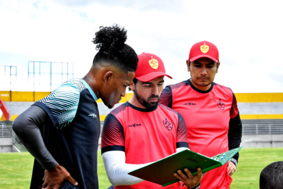 El entrenador Gerardo Espinoza (c) dialoga con sus pupilos sobre el estilo de juego.