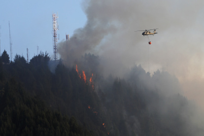 Un helicóptero combate este miércoles 24 de enero de 2024 un incendio forestal en el cerro El Cable, en Bogotá (Colombia).