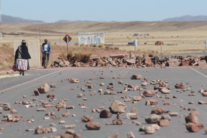 Indígenas aparecen junto a una carretera en Tiwanacu (Bolivia), que ha sido bloqueada.