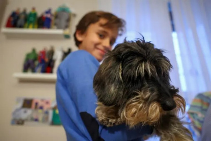 El niño Javier Bañuelos, trasplantado, posa junto a su mascota de terapia.