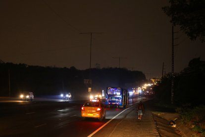 Sombras. Las personas deben transitar bajo la tenue iluminación de los faroles de los automóviles que circulan en la vía Perimetral; a la altura del viaducto de La Prosperina no hay luz.