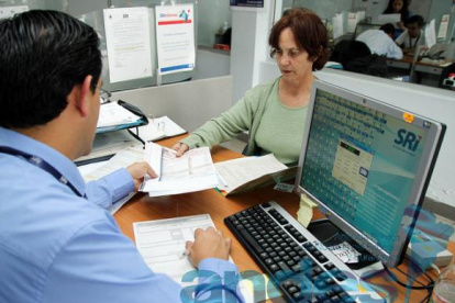 FUNCIONARIO DEL SRI ATIENDE A UNA MUJER CONTRIBUYENTE.