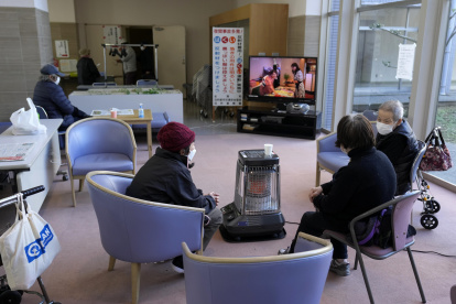 Shika. Un grupo de damnificados se sientan alrededor de un calentador en un centro de evacuación.