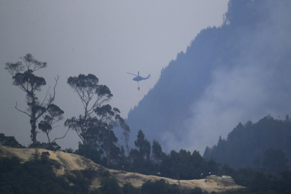Un helicóptero combate este lunes 29 de enero de 2024 un incendio forestal en el cerro El Cable, en Bogotá (Colombia).