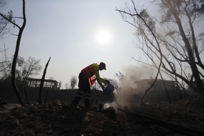 Bomberos y voluntarios tratan de extinguir los focos de un incendio en la zona de Patagual, en Viña del Mar (Chile).