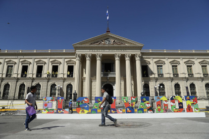 Personas caminan frente al Palacio Nacional, en el centro de San Salvador.