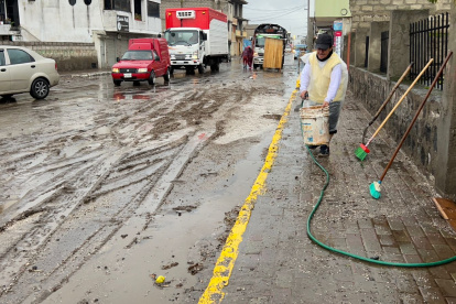 Con escobas y baldes los moradores trataban de limpiar el lodo que se formó