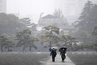 Unas personas caminan durante las nevadas en los jardines que rodean el Palacio Imperial en Tokio, Japón, el 5 de febrero de 2024.