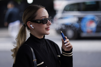 Una mujer utiliza un vapeador