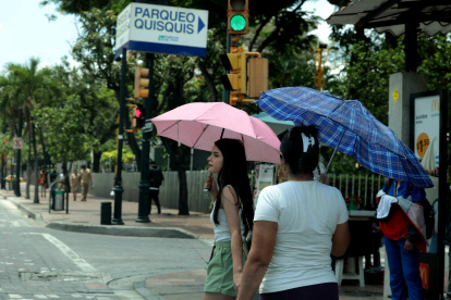 Temperatura. Ciudadanos se protegen del sol con sombrillas.