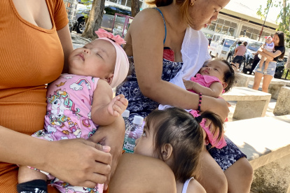 Madres filipinas y sus bebes en la entrada de un centro de salud.