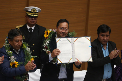 El presidente de Bolivia, Luis Arce (c), sostiene la ley para elecciones judiciales tras su promulgación este 6 de febrero de 2024, en la "Casa Grande", en La Paz (Bolivia).