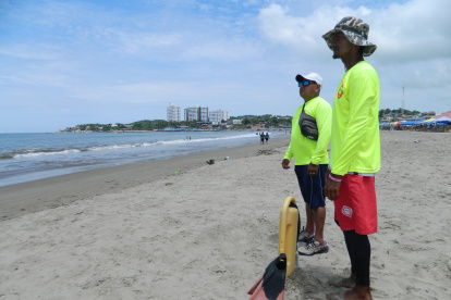 Dos salvavidas vigilan a los escasos bañistas en un sector de la playa de General Villamil.