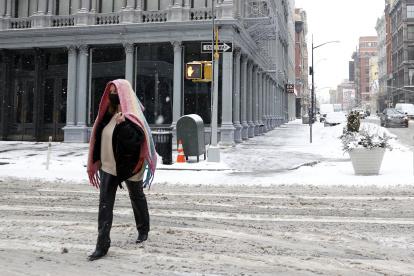 Nueva York. Una persona camina por una calle cubierta por la nieve.