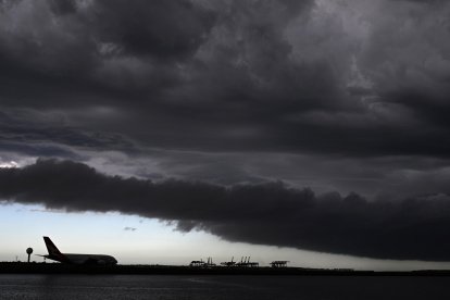 Un avión espera mientras las nubes de tormenta pasan sobre Botany Bay en Sydney, Australia, el 13 de febrero de 2024.