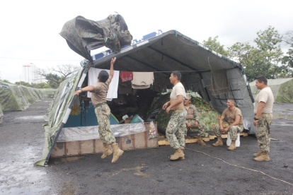 Personal de tropa coloca plásticos en las carpas del campamento para evitar mojarse con las constantes precipitaciones.