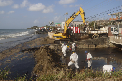 Unos trabajadores limpian un derrame de petróleo, el 12 de febrero del 2024, en la playa Rockly Bay, en la ciudad de Scarborough en la isla Tobago (Trinidad y Tobago).