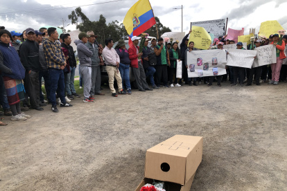 Los productores de claveles realizaron un plantón, todos llevaban carteles y ramos de claveles.