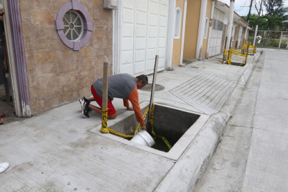 Los moradores de Samanes 6 utilizan baldes para sacar el agua que se estanca en lo que se supone deben ser jardineras.