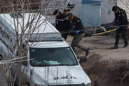 Peritos forenses trasladan un cuerpo localizado en una fosa clandestina el 16 de febrero de 2024, en Ciudad Juárez.