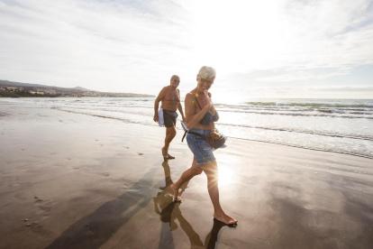 En la imagen de archivo, un hombre y una mujer pasean por la orilla de la Playa del Inglés (Gran Canaria, España).