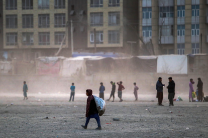 Un niño afgano busca residuos reciclables para venderlos a las fábricas, al borde de una carretera en Kabul, Afganistán, el 24 de enero de 2024.