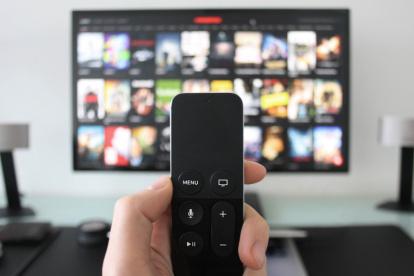 EL STREAMING - MANO SOSTENIENDO UN CONTROL REMOTO FRENTE A LA TELEVISIÓN |