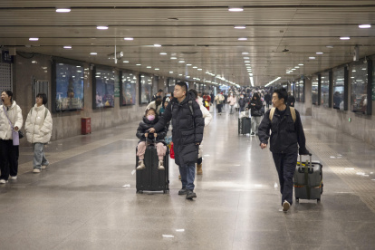 Pekín. Familias enteras esperan su tren en la estación de esta capital.