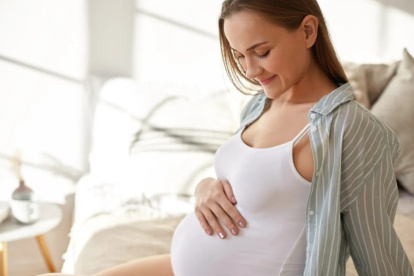 Embarazada observa su vientre con emoción