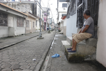 Muros. Raúl Pincay mira con resignación que muchos vecinos han debido construir muros y elevar sus pisos para evitar que el agua, ya sea por marea alta o lluvias, ingrese a sus casas.