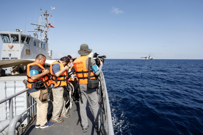 Medios de comunicación trabajan durante una operación conjunta de las Armadas tailandesa y estadounidense para rescatar los restos del barco.
