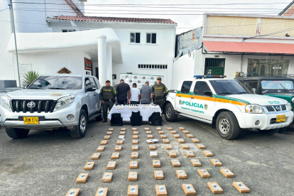 Las tres personas detenidas con la droga decomisada.